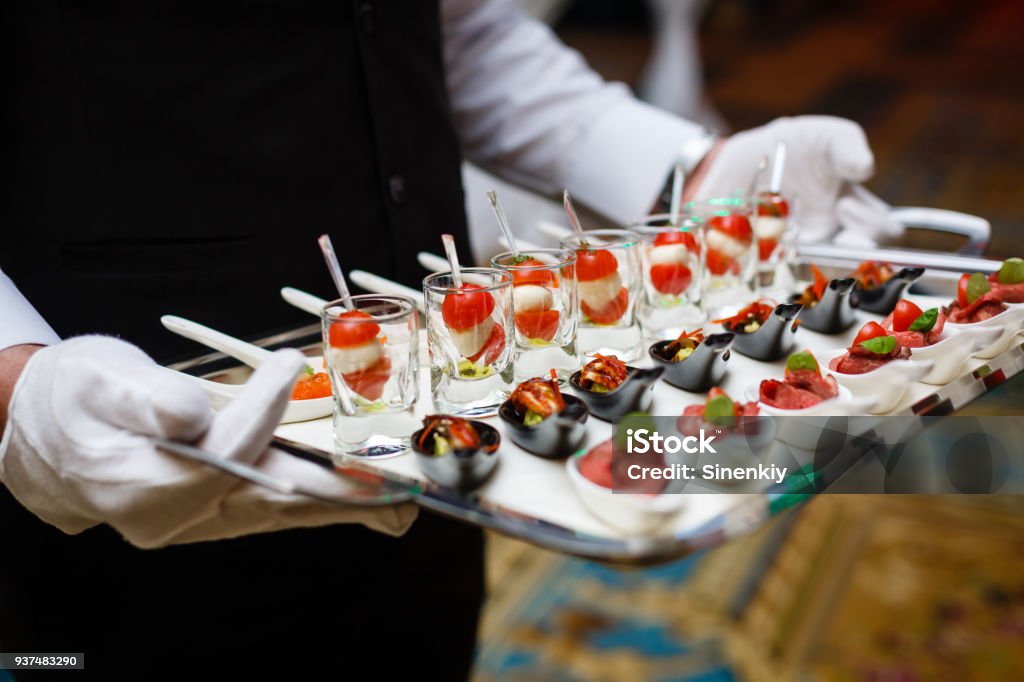 Server holding a tray of appetizers at a banquet Food And Drink Industry Stock Photo