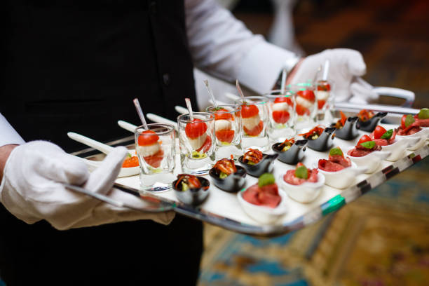 servidor segurando uma bandeja de aperitivos em um banquete - indústria de comida e bebida - fotografias e filmes do acervo