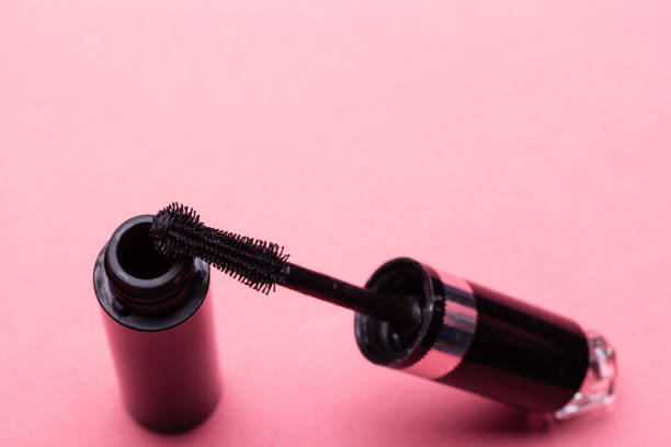 istock Eyelash makeup brush and mascara bottle close up on pink background with copyspace 937491040