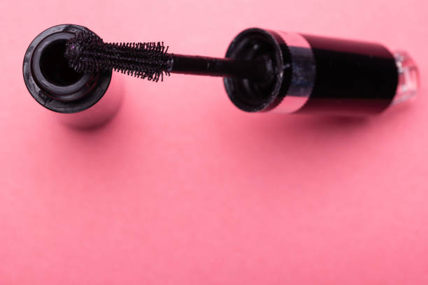 istock Eyelash makeup brush and mascara bottle close up on pink background with copyspace 937491072