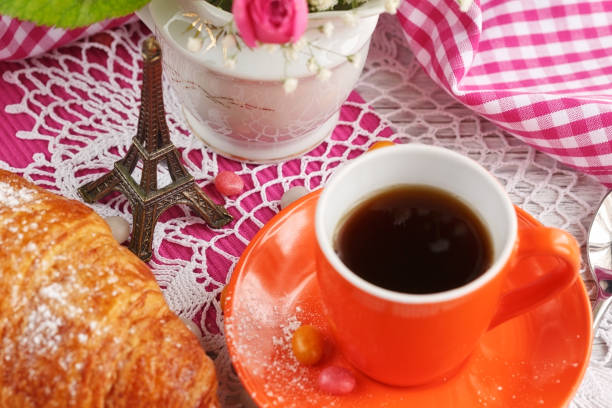 istock cup of coffee and croissant with the small Eiffel Tower 937498304