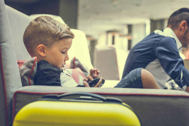 istock Small boy playing video games in hotel lobby. 937504484