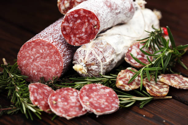 istock thinly sliced salami on a wooden texture on the background. 937519768