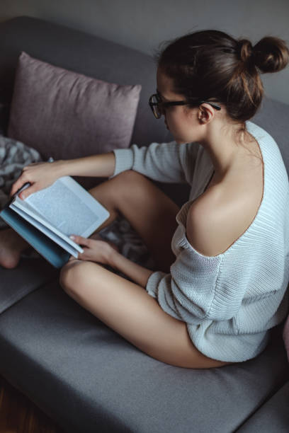istock Over shoulder view of a girl reading a book 937523640
