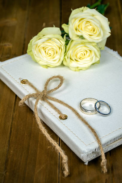 istock wedding rings and roses on book 937527720