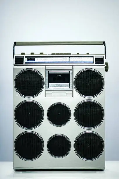 An image of a personal tape player stereo sound system from the late 1980s - early 1990's, changed to have many speakers.  A depiction of excess, sound, or music humor.