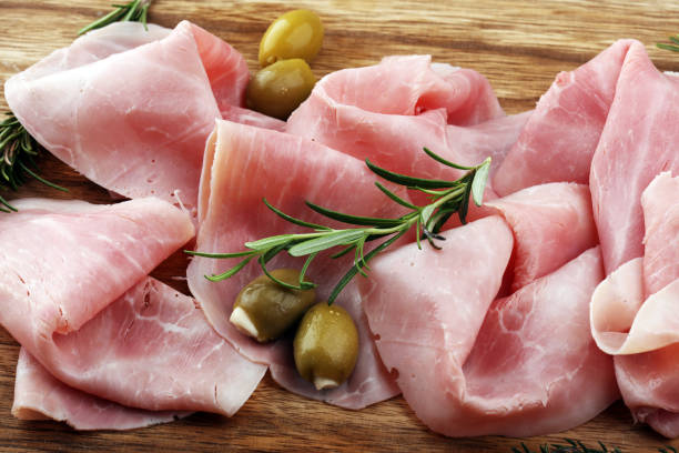 istock Sliced ham on wooden board. Fresh prosciutto. Pork ham sliced. 937539504