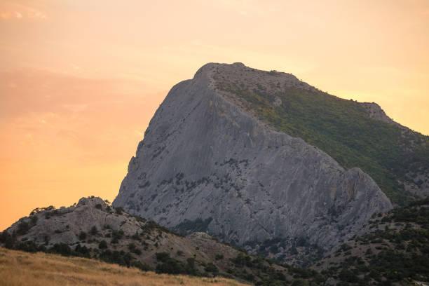 highest mountain with steep slope at dawn or sunset light pale pink sky