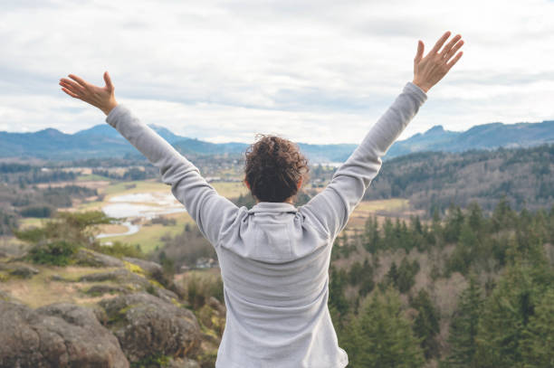 istock Young ethnic female hiker raises her hands in enthusiasm 937550542