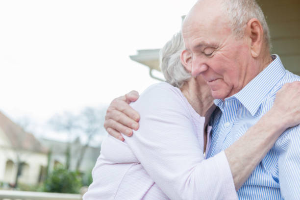 istock Senior couple embrace on front porch 937553068