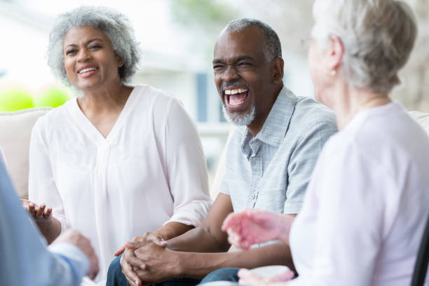 istock Senior man laughs with friends on front porch 937553120