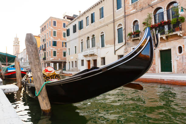 gondel am kanal pier festgemacht - venice italy gondola gondolier sunset stock-fotos und bilder