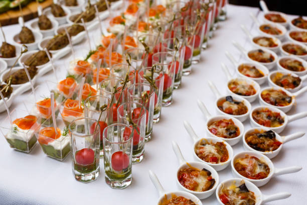 vasitos con ensaladas frescas soporte en mesa blanca - sales meeting fotografías e imágenes de stock