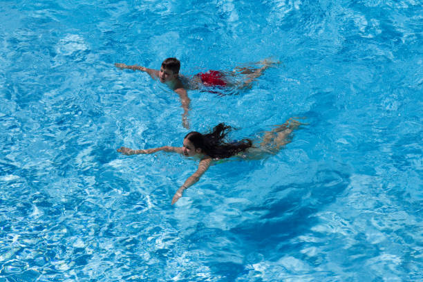 istock Two kids swim in pool together 937564906