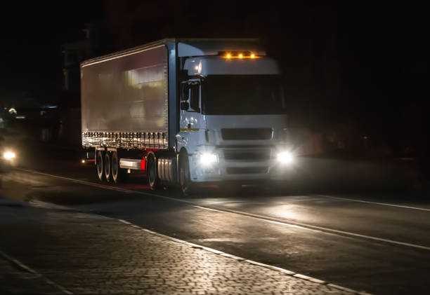 istock truck moves on highway at night 937569116