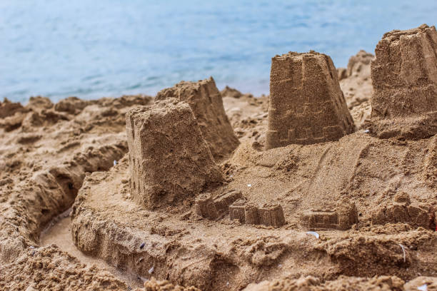istock A sandcastle on a sandy beach, set against a bright blue sea water 937571466
