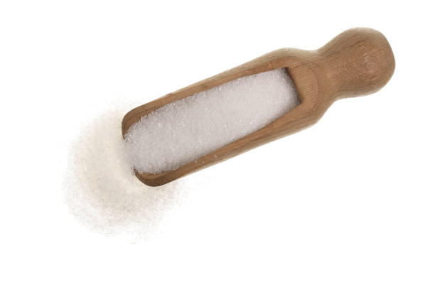 istock granulated sugar in wooden spoon isolated on white background. Top view. Flat lay 937594828