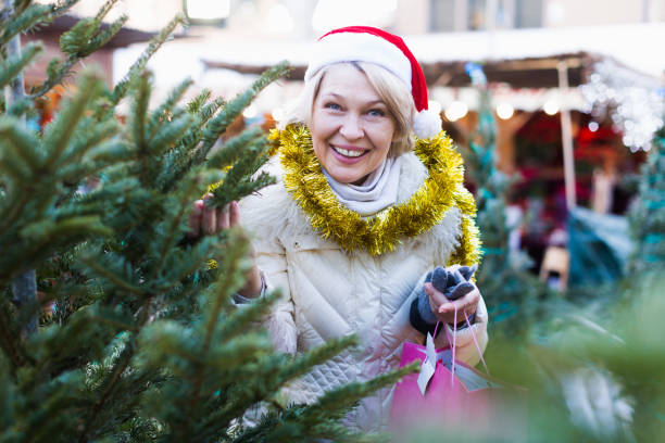istock Woman is preparing for Christmas and choosing X-mas tree 937602038