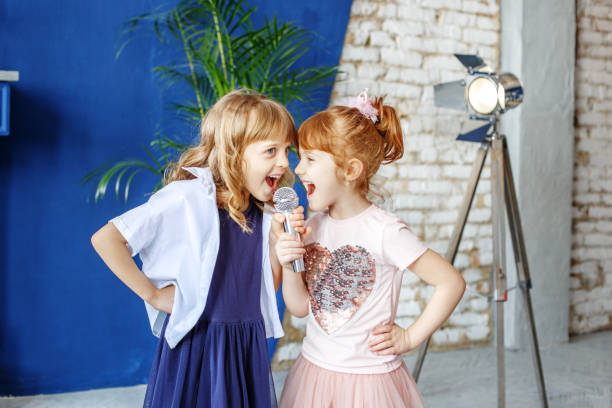 istock Two little funny children sing a song in a microphone. Group. Th 937602434