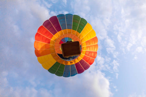 colorido globo aerostático volando sobre cielo azul y nubes blancas - heat mid air flying float fotografías e imágenes de stock