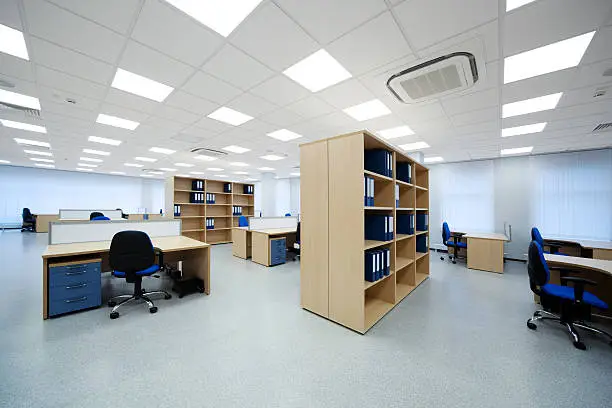 Photo of A view of the inside of an office with desks and shelves