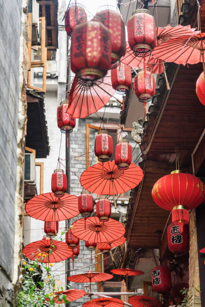 Traditional Chinese red lanterns and umbrellas, Fenghuang Fenghuang, China - September 22, 2017: Traditional oriental Chinese red lanterns and umbrellas at narrow street of Phoenix Ancient Town (Fenghuang). Fenghuang is a popular tourist destination of Asia. phenix stock pictures, royalty-free photos & images