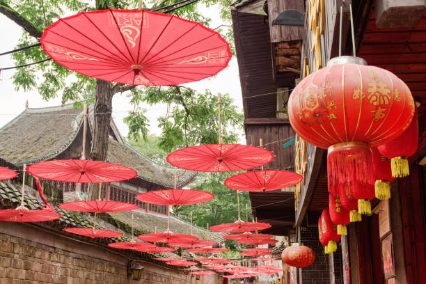 Street decorated with Chinese red lanterns and umbrellas Fenghuang, China - September 22, 2017: Amazing narrow street decorated with row of traditional oriental Chinese red lanterns and umbrellas in Phoenix Ancient Town (Fenghuang). phenix stock pictures, royalty-free photos & images