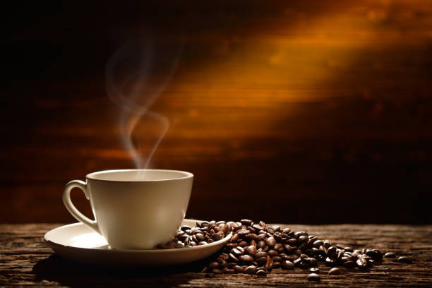 istock Coffee cup and coffee beans on old wooden background 937645710