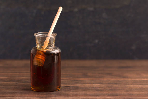 istock Honey with a Honey Spoon in a Glass Container 937645822