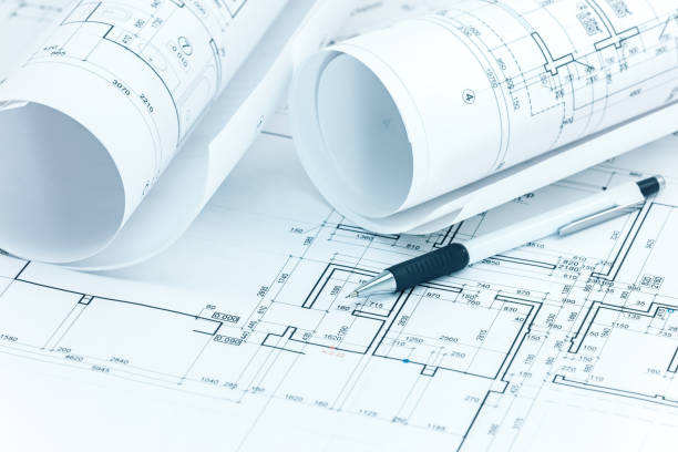 istock architectural plans, blueprint rolls and pencil on architect desk 937656040
