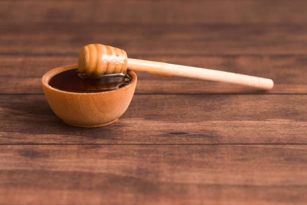 istock Honey with a Honey Spoon in a Small Wooden Bowl 937656358