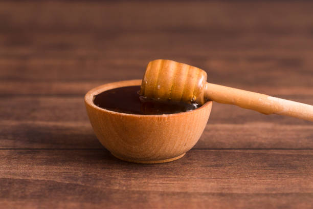 istock Honey with a Honey Spoon in a Small Wooden Bowl 937658470