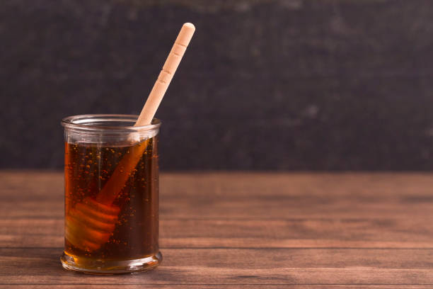 istock Honey with a Honey Spoon in a Glass Container 937658476
