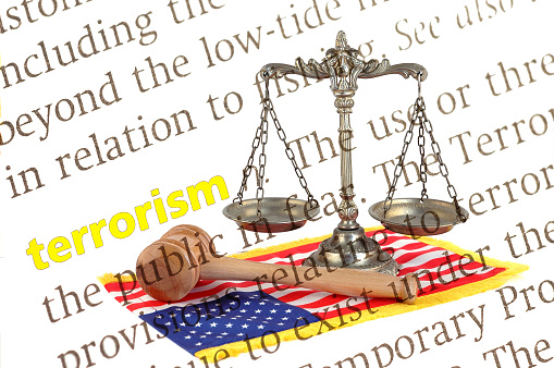 dictionary definition of terrorism with Scales of justice, gavel and American flag