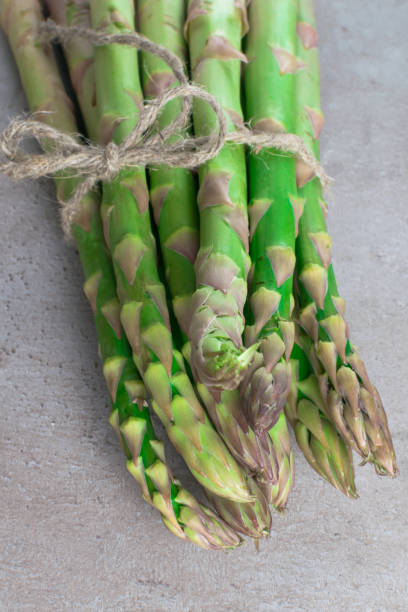 istock raw green asparagus on the wood background 937685620