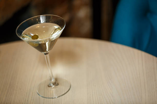 istock glass with martini , focus on a olives 937689782