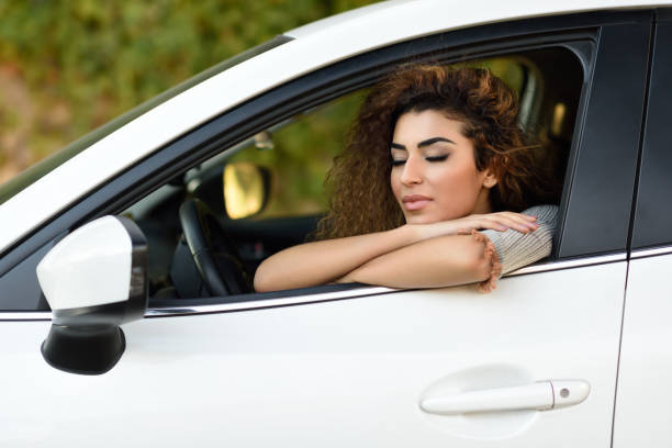 istock Young arabic woman inside a white car with eyes closed 937694016