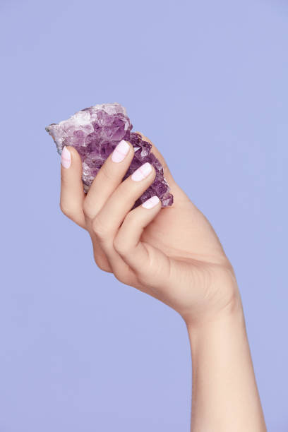 istock Manicure. Hand With Stylish Nails Holding Purple Gemstone 937698058