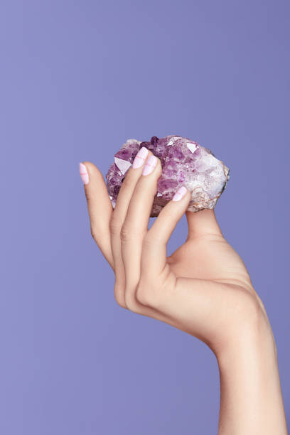 istock Manicure. Hand With Stylish Nails Holding Purple Gemstone 937698084