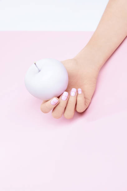 istock Woman Hand With Pink Pastel Nails And Apple 937700286