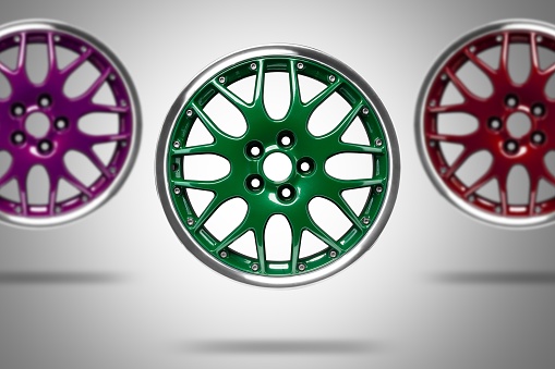 Colorful alloys rims floating in the air at grey background