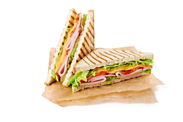 istock Sandwich with ham, cheese, tomatoes, lettuce, and toasted bread. Above view isolated on white background. 937703334