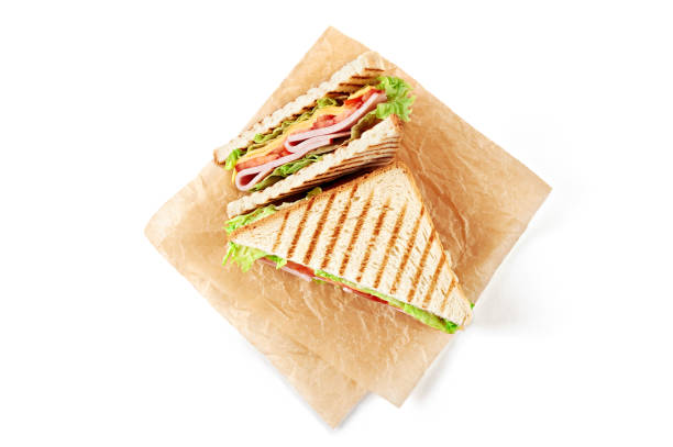 istock Sandwich with ham, cheese, tomatoes, lettuce, and toasted bread. Above view isolated on white background. 937703340