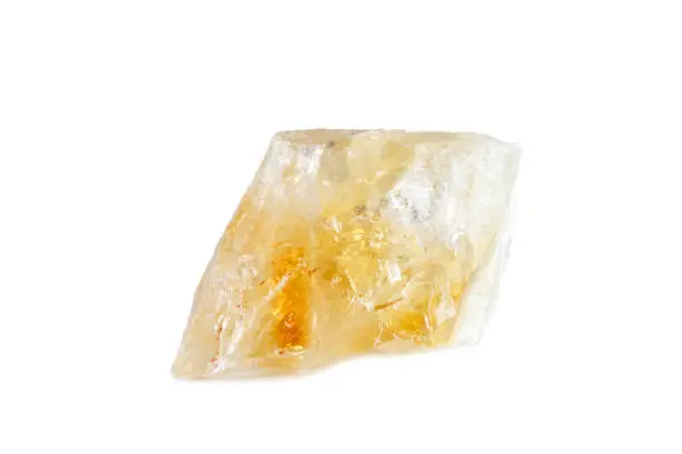 Macro shooting of natural gemstone. The raw mineral is citrine. Brazil. Isolated object on a white background