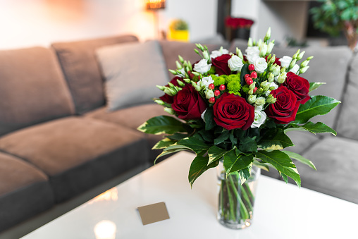 Bouquet of roses standing on the white table in modern saloon