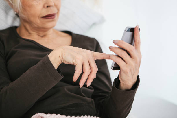 istock A positive modern elderly woman is holding a cell phone and is using it. The older generation and modern technology. 937712604