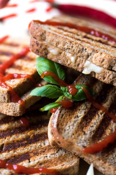 istock Toasted bread with cheese and ham on a wooden plate 937720178