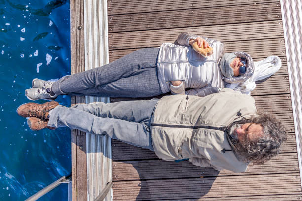 istock beautiful mature couple relaxing lying on the dock 937723018