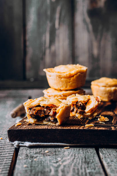 traditionellen australischen frischfleisch mini kuchen auf dem holzbrett auf tabellenhintergrund, closeup mit textfreiraum, rustikalen stil - beef pie stock-fotos und bilder