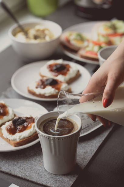 istock Woman pouring milk into the coffee 937726262